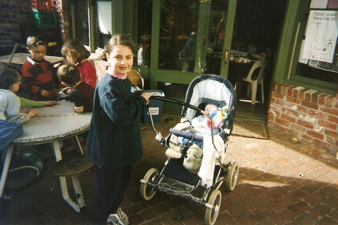 Girl and baby in pram